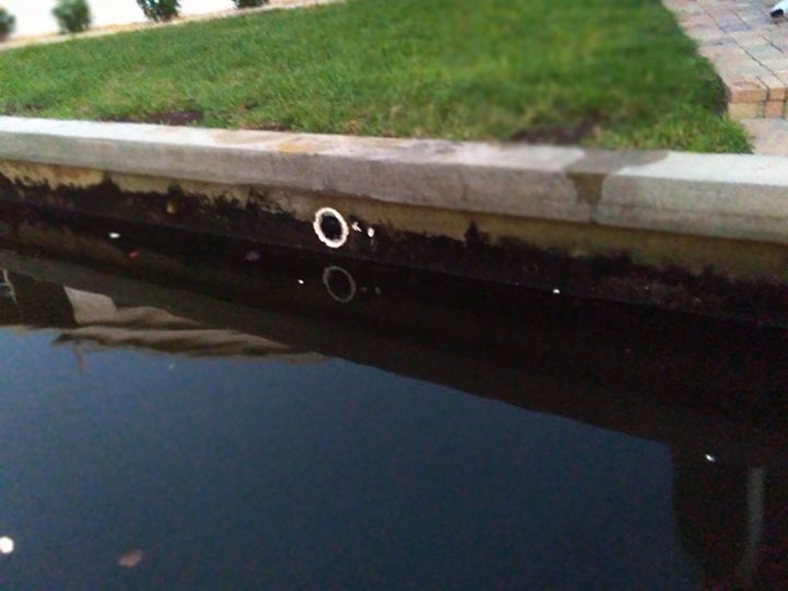 Damaged seawall with holes visible at waterline